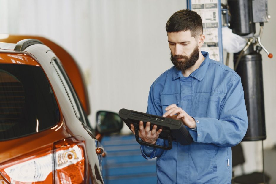Mecânico usando scanner de diagnóstico eletrônico em um carro