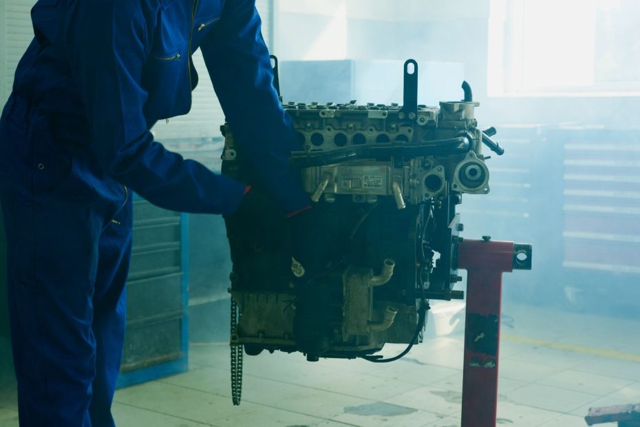 Mecânico segurando um motor de carro removido para reparo